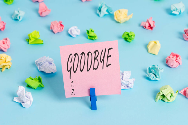 Writing note showing Goodbye. Business photo showcasing used to express good wishes when parting or end of a conversation Colored crumpled papers empty reminder blue floor background clothespin. - Photo, Image
