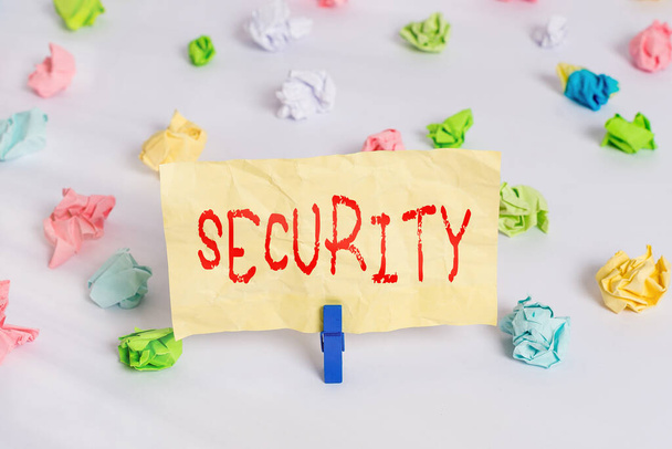 Text sign showing Security. Conceptual photo measures taken to be safe Quality or state of being secure Colored crumpled papers empty reminder white floor background clothespin. - Photo, Image