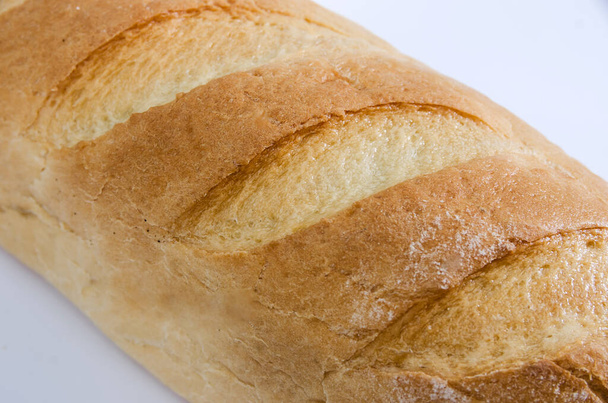 lunga pagnotta su fondo bianco. Pezzo di pane, consistenza del pane. Primo piano
. - Foto, immagini
