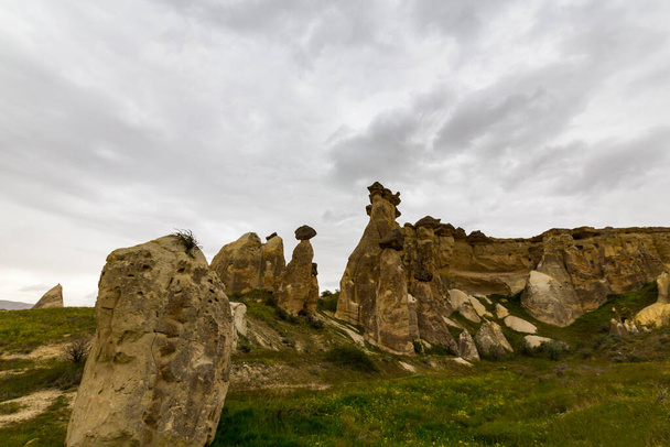 Limestone rock formations under dramatic storm clouds, in Cappadocia, Turkey - Foto, afbeelding