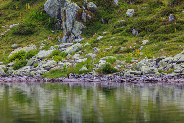 Sommerlandschaft in den Siebenbürgischen Alpen mit Granitfelsen, Gletschersee und Gewitterwolken - Foto, Bild