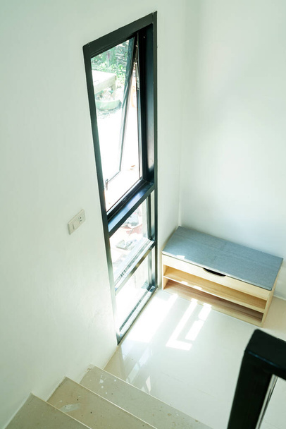 Moderno zapatero de madera caja en acogedora sala de estar blanca decoración casera
 - Foto, Imagen