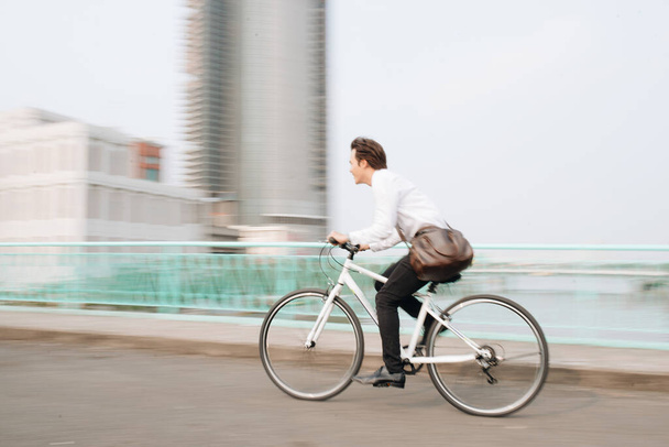 Imagem desfocada do homem asiático louco andar de bicicleta na cidade urbana pendulares com velocidade e hipster moderno transporte
 - Foto, Imagem