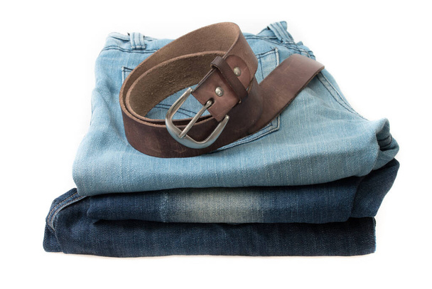 Blaue Jeans und Ledergürtel auf weißem Hintergrund. - Foto, Bild