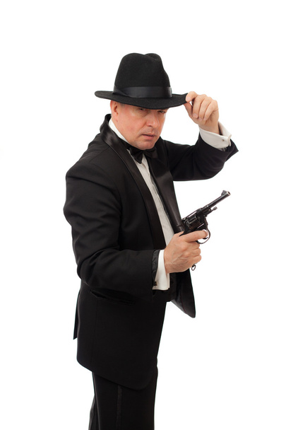 The elegant man in a tuxedo with a hat and a revolver on a white background - Фото, зображення