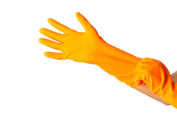 Ludzka ręka nosi pomarańczową gumową rękawicę izolowaną na białym tle. ścieżki wycinania. - Zdjęcie, obraz