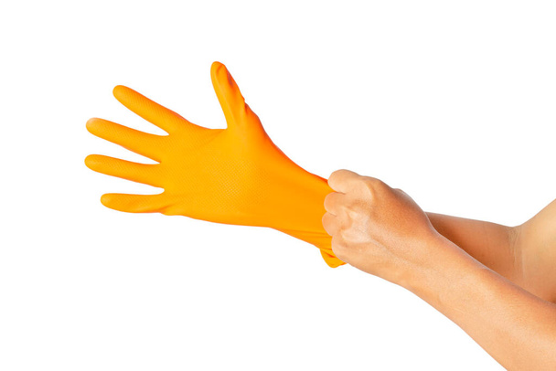 La mano humana lleva un guante de goma naranja protector aislado sobre fondo blanco. caminos de recorte
. - Foto, imagen