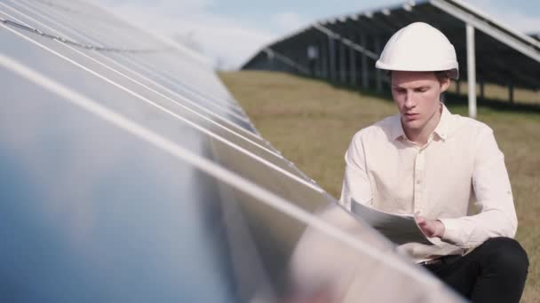 A man is checking the solar power panel at the plant - Materiał filmowy, wideo