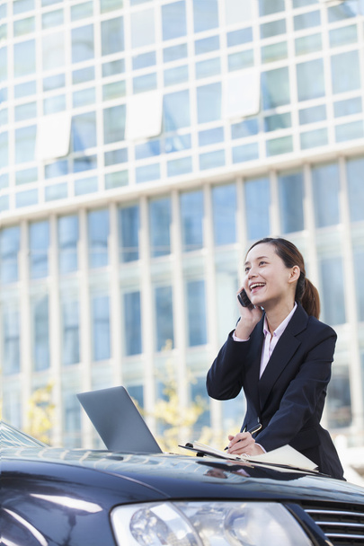 Businesswoman Standing by Car Using Phone - Foto, imagen