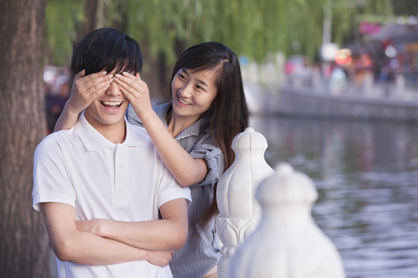 Woman Covering Mans Eyes by a Lake - Photo, Image
