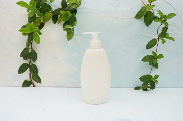 Καλλυντικό δοχείο μπουκαλιού με πράσινα φύλλα βοτάνων, λευκή συσκευασία ετικέτας για το branding mock-up, Έννοια προϊόντος φυσικής βιολογικής ομορφιάς. - Φωτογραφία, εικόνα