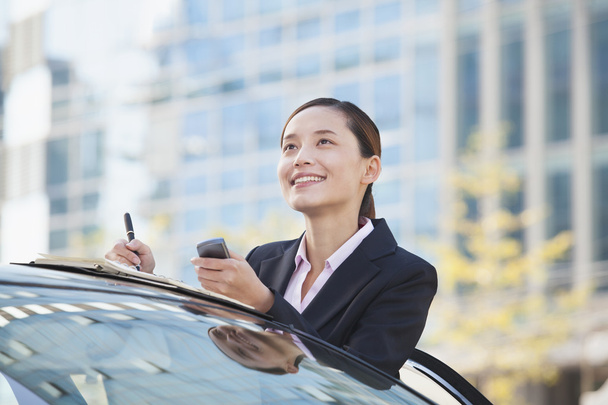 Businesswoman Standing by Car Using Phone - Фото, зображення