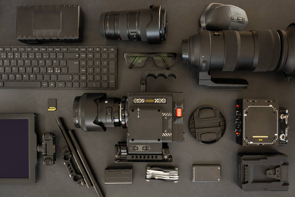 Flat lay of filming equipment with keyboard and eyeglasses on table - Fotoğraf, Görsel