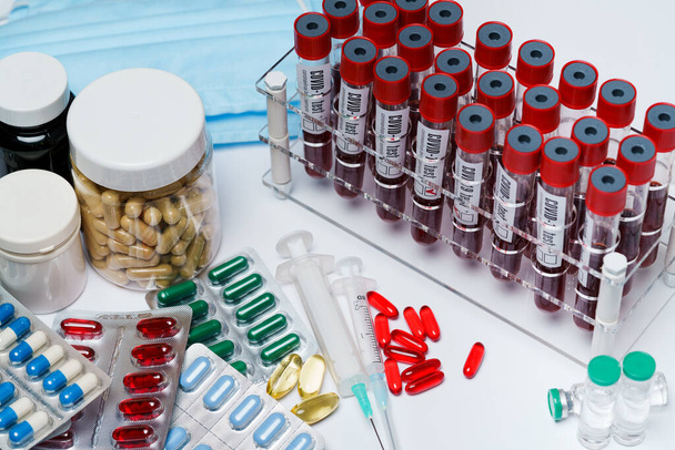 packings of pills and capsules of medicines and blood test tubes - Photo, image