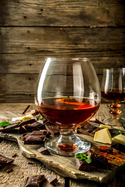 Strong alcohol drink. Glass of brandy, whiskey or cognac on the wooden table - Foto, afbeelding