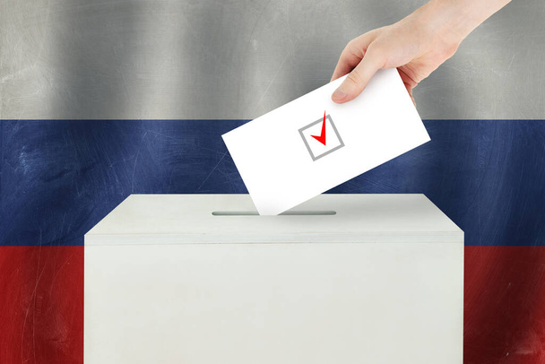 ロシアの投票概念。投票所での投票のための投票用紙を保持する投票手 - 写真・画像