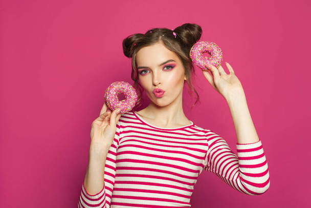 Όμορφο κορίτσι με ντόνατς σε ζωηρό ροζ φόντο - Φωτογραφία, εικόνα