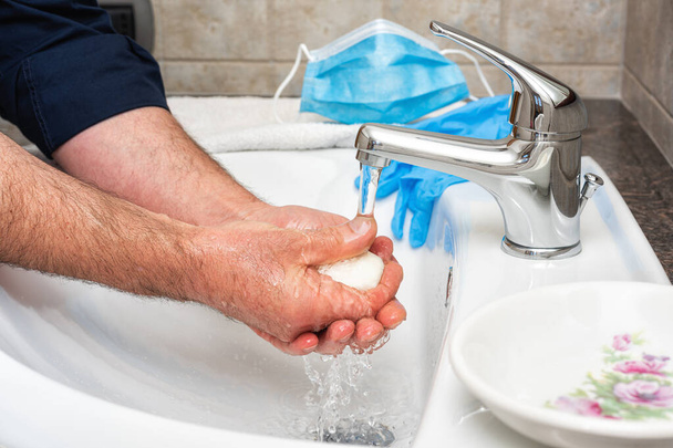 Zapobieganie koronawirusom. Mycie rąk gorącą wodą z mydłem, użycie maski i rękawic zapobiega infekcji wywołanej przez Covid-19. Higiena osobista. Zdrowie. - Zdjęcie, obraz