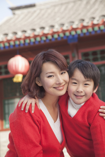 Mãe e filho fora do edifício chinês tradicional
 - Foto, Imagem