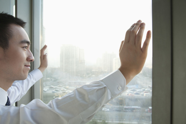 νέος επιχειρηματίας ψάχνει έξω από το παράθυρο - Φωτογραφία, εικόνα