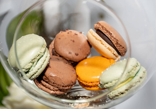 Many different colored macaroons in a festive Christmas transparent globe hanging in a festive decoration during brunch or catering event - Foto, Bild