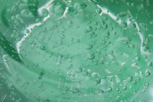 Pure transparent cosmetic gel on green background, closeup - Foto, immagini