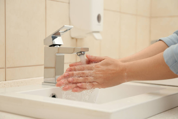 Woman washing hands with antiseptic soap in bathroom, closeup. Virus prevention - Foto, immagini