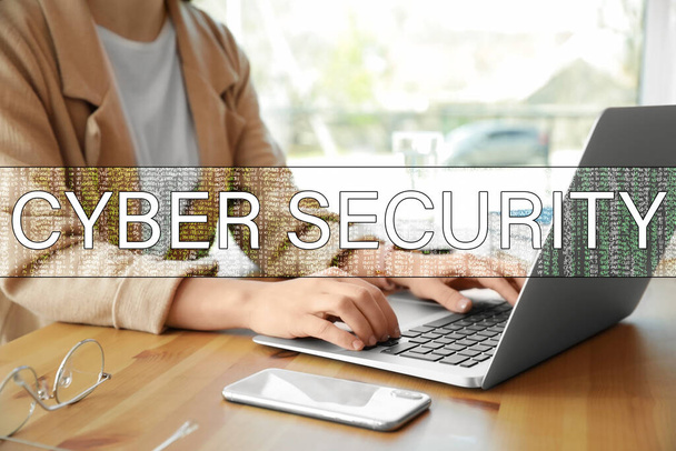 Koncept kybernetické bezpečnosti. Žena pracující s laptopem u stolu uvnitř, detailní záběr - Fotografie, Obrázek