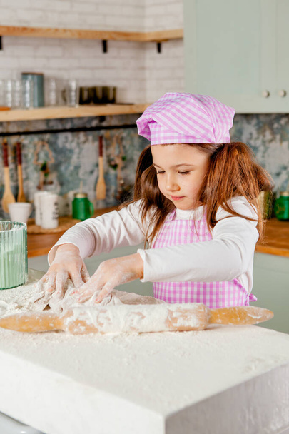 Girl in the kitchen kneads gingerbread dough - Fotoğraf, Görsel