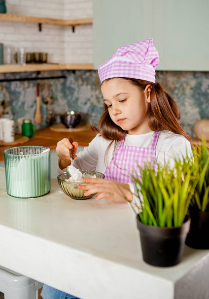 дівчина на кухні замішує тісто
 - Фото, зображення