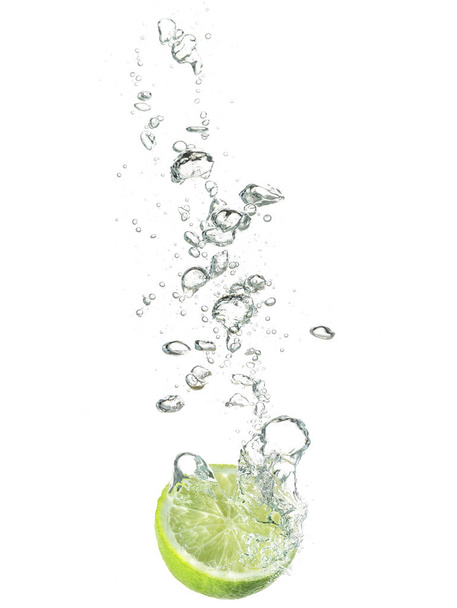 lime dropped in water isolated on white - Fotoğraf, Görsel