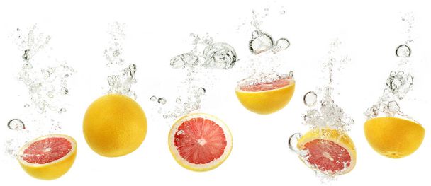 набор грейпфрутов, падающих в воду на белом фоне
 - Фото, изображение