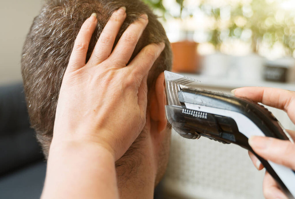 Kadın evde saç kesme makinesiyle saçını kestiriyor.. - Fotoğraf, Görsel