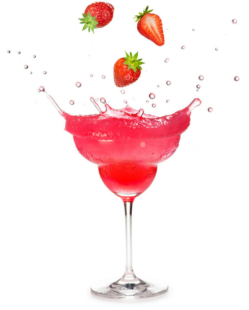 strawberries dropping into a frozen strawberry cocktail splashing on white background - 写真・画像