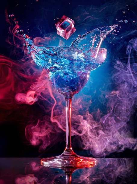 glaçon tombant dans éclaboussures cocktail sur fond fumé
 - Photo, image