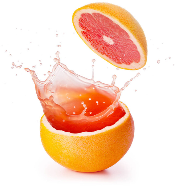 red juice splashing out of a grapefruit isolated on white background - Photo, Image