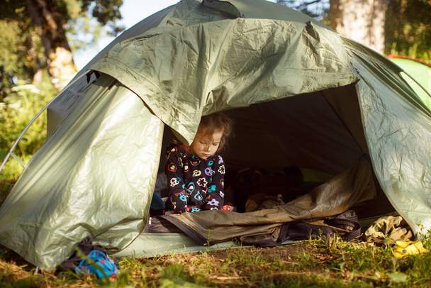 little girl woke up in in the tent camp. camping. - Foto, immagini