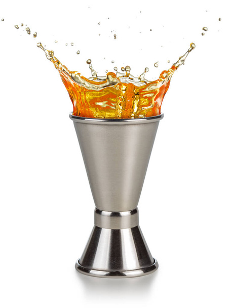 orange liquor spilling out of a jigger isolated on white background - Photo, Image