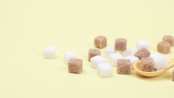 Weißer und brauner Zucker in Stücken auf gelbem Hintergrund. - Filmmaterial, Video