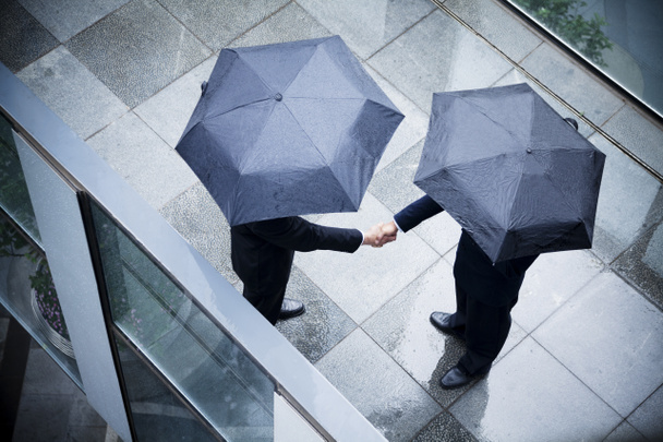 biznesmeni drżenie rąk w deszczu - Zdjęcie, obraz