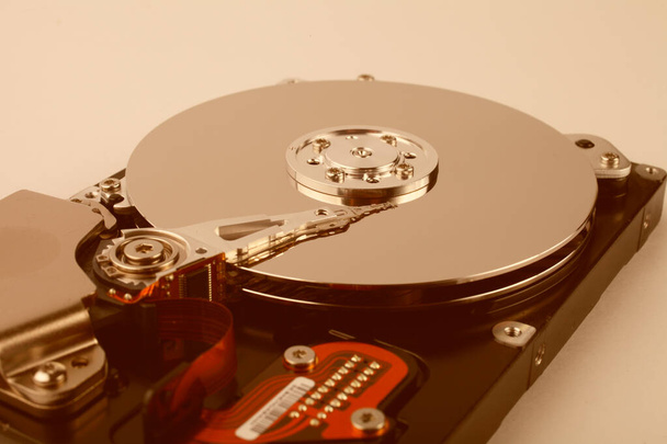 Αποσυναρμολογημένος σκληρός δίσκος υπολογιστή με δίσκους καθρέφτη σε λευκό φόντο, απαλή εστίαση, τονισμένο πορτοκαλί χρώμα. - Φωτογραφία, εικόνα