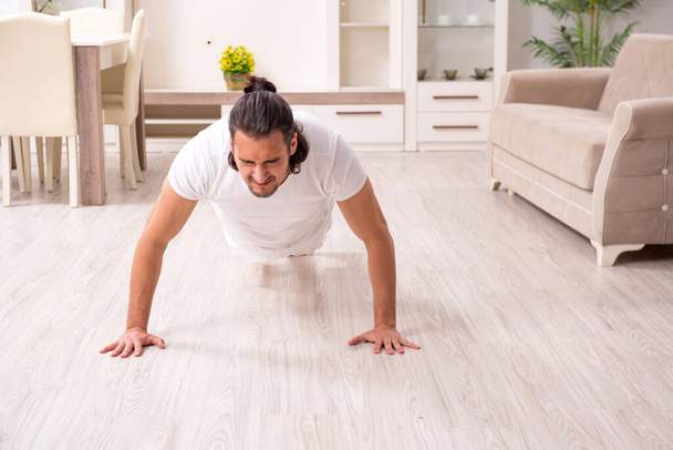 Young man doing physical exercises at home - Foto, Imagem