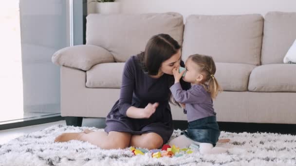 Beautiful mother and toddler daughter are playing construction toys together in a room - Πλάνα, βίντεο