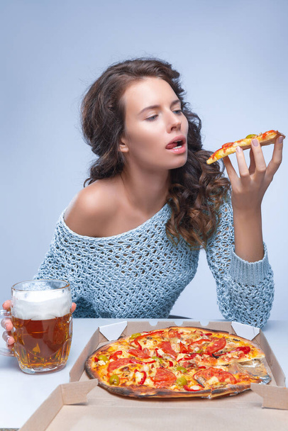 Mujer feliz con pizza y cerveza sobre fondo gris, espacio para texto - Foto, Imagen
