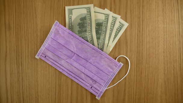 Медицинские маски и доллары на столе
. - Фото, изображение