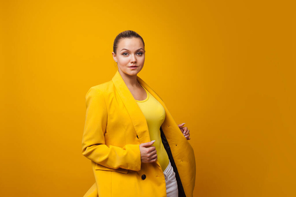 Stylish positive young woman on yellow background, copy space. - Valokuva, kuva