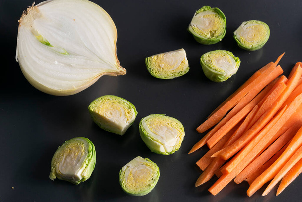 Taca z upuszczonymi warzywami, marchewką, kapustą i cebulą. Dania wegetariańskie. - Zdjęcie, obraz