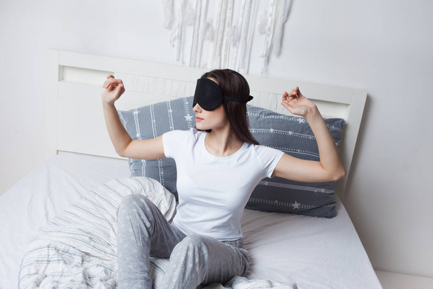 Young woman woke up in the morning in bed wearing a sleep mask, good morning - Photo, Image