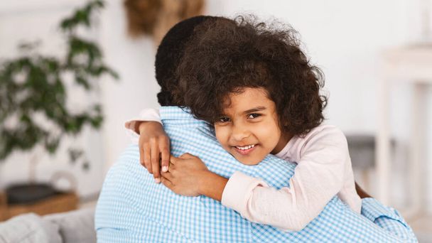 Grandparent grandchild closeness. Curly African American girl embracing her grandpa indoors. Panorama - Φωτογραφία, εικόνα