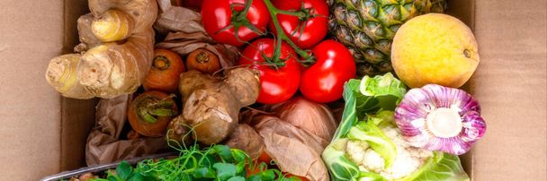 Χαρτοκιβώτιο μηδενικού παντοπωλείου με βιολογικά υγιεινά τρόφιμα καθαρή διατροφική επιλογή, φρούτα, μικροπράσινα, λαχανικά, πράσινα φύλλα. Τρόφιμα πλούσια σε φυτικές ίνες, βιταμίνη, αντιοξειδωτικά, κοντά - Φωτογραφία, εικόνα